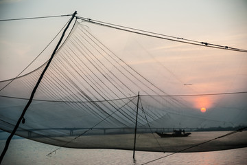 Fototapeta premium Calm scene of fishing net against purple sunset.