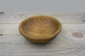 Fototapeta na wymiar Empty bowl on old wooden surface. Closeup.