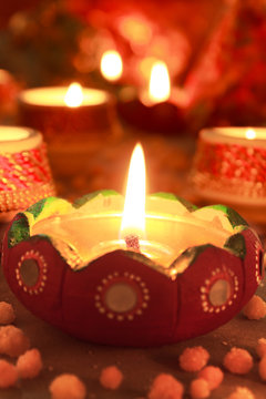 Diwali, celebration of lights.Glowing Red Diya arranged in a row along with some spread of north Indian Sweet Bhoondhi.