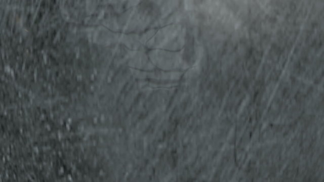 A regular metal wrecking ball attached to a chain swinging to and fro on a blue screen background