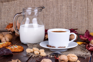 Coffee cup, cream, coffee grains and oatmeal cookies