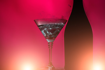 Bottle and goblet on pink