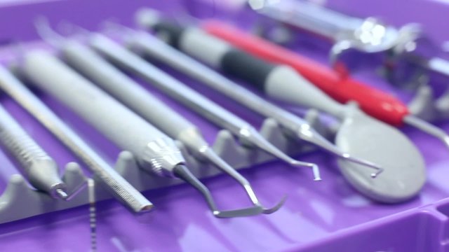 Different dental instruments on a purple tray / camera moving right / close-up
