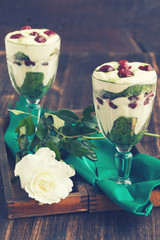 Tiramisu in a glass of tea match and cherry.Toned image. Vintage style.selective focus.