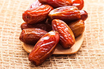 dried dates on wooden spoon cloth background