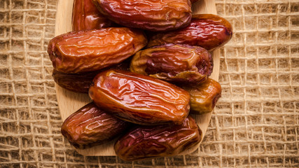 dried dates on wooden spoon cloth background
