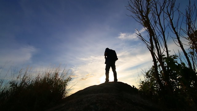 Silhouette of Photographer standing on the mountain in sunset time