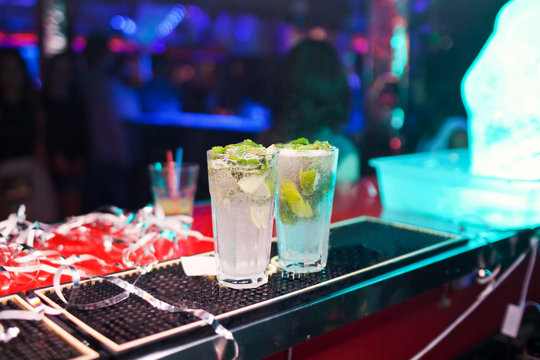 Two Mojito cocktails on a bar counter