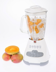 Licuadora, con fruta y jugo sobre fondo blanco.