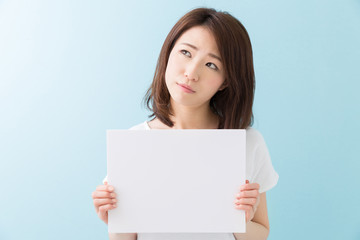 Fototapeta premium ホワイトボードを持つ女性 考える