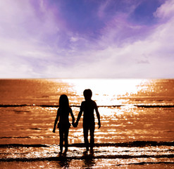 Silhouette boy and girl on the sea