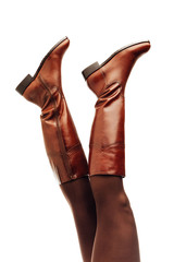 woman legs wearing brown leather high boots upside down