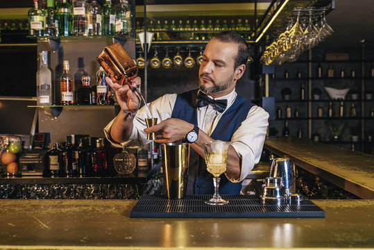 Barman is making cocktail at night club