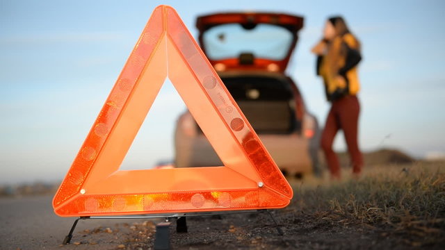 Young woman with a triangle which has broken down
Warning triangle close-up 