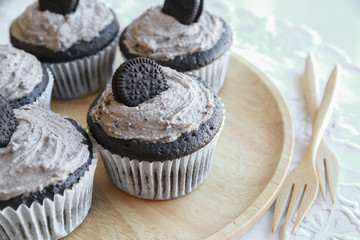 Homemade dark chocolate cupcakes with cookie and cream frosting
