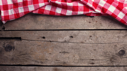 Red  checkered kitchen towel  on vintage  wooden background.