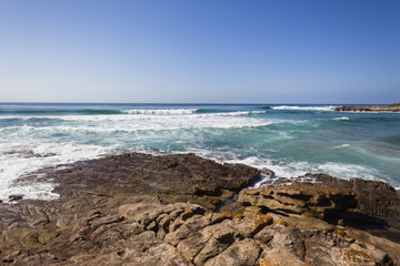 Fototapeta na wymiar Ocean Rocky Coastline with blue water waves landscape