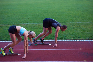 woman group  running on athletics race track from start