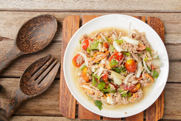 Spicy Tuna Salad onion and tomatoes in plate put on wooden background , Thailand cuisine.