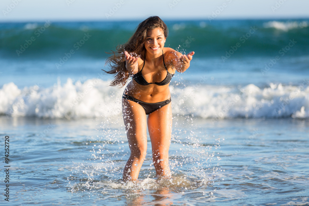 Wall mural splashing water beach ocean cute fun beautiful mixed race model perfect shape body bikini swimsuit l