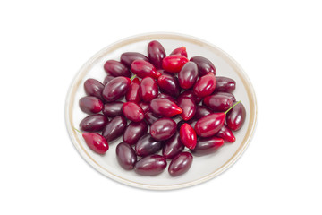 Berries of European cornel on saucer on a light background