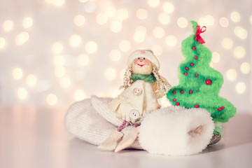 Christmas background with woolen angel, mittens and christmas tr