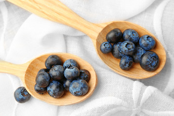 Fresh blueberries in spoons on table close up
