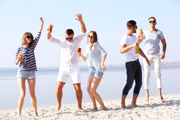 Obraz premium Young people with beer on the riverside