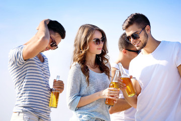 Young people with beer on the riverside