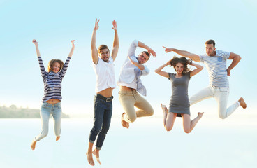 Young people with beer on the riverside