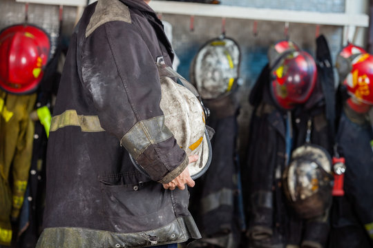 Fireman Holding Helmet At Fire Station