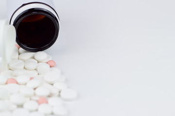 Colorful pills and pill bottle on the white background