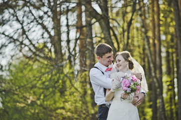 Newlyweds hugging on the background of the forest 3976.