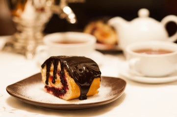 On the white tablecloth is a samovar, a teapot, a cup of tea and sweets, biscuits, rolls, tea,