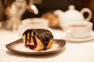 On the white tablecloth is a samovar, a teapot, a cup of tea and sweets, biscuits, rolls, tea,