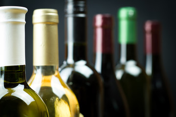 Wine bottles in a row isolated on a gray background