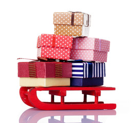 Fototapeta na wymiar Red sled full of gift boxes, isolated on white background