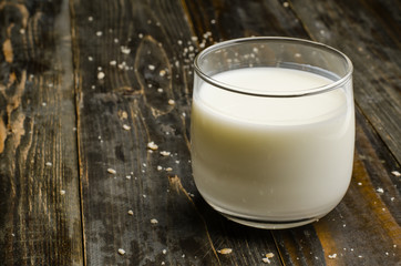 Glass of milk on wooden background