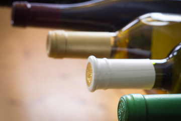 Wine bottles stacked on wooden racks shot with limited depth of - obrazy, fototapety, plakaty