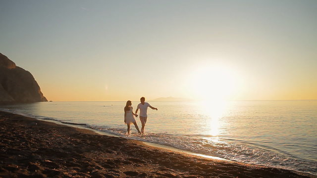 beautiful couple walking along the shore of the Aegean Sea