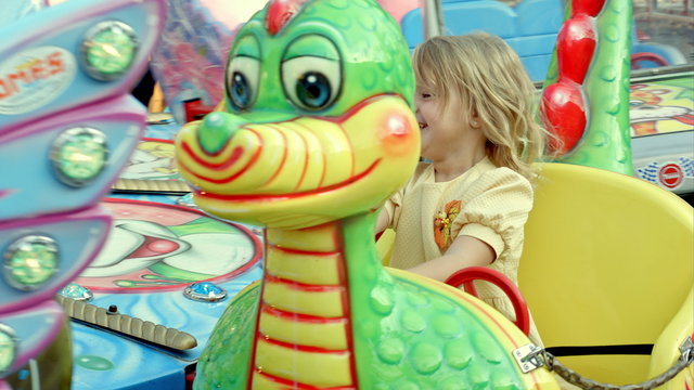 Girl riding a colorful carousel