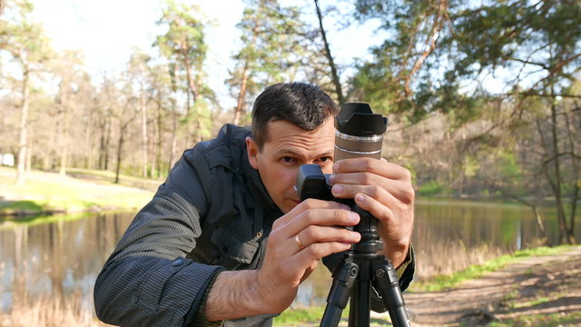  man  photographer adjusts  camera.4K 3840x2160