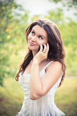 Outdoor portrait of young woman with phone