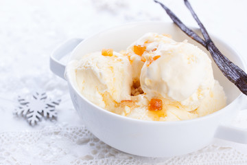 Vanilla ice cream with candied oranges on a white background for Christmas. Closeup.