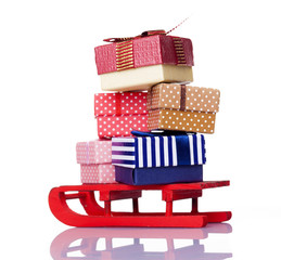 Fototapeta na wymiar Red sled full of gift boxes, isolated on white background