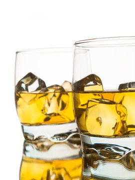 Two glasses of whiskey on the rocks over white background