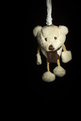 Pupazzo appeso e impiccato su sfondo nero