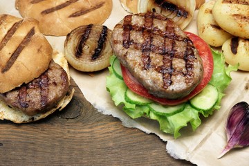 Picnic Table Top With BBQ Grilled Burgers And Vegetables
