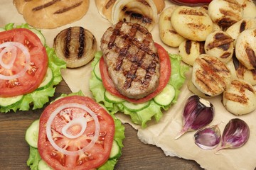 Picnic Table Top With BBQ Grilled Burgers And Vegetables