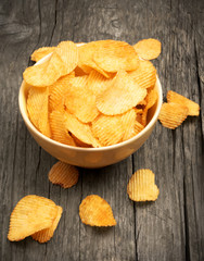 crispy potato chips on wooden background